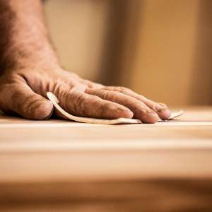 A carpenter sand papers wood