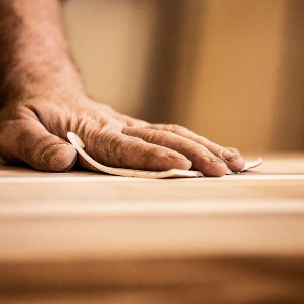 A carpenter sand papers wood