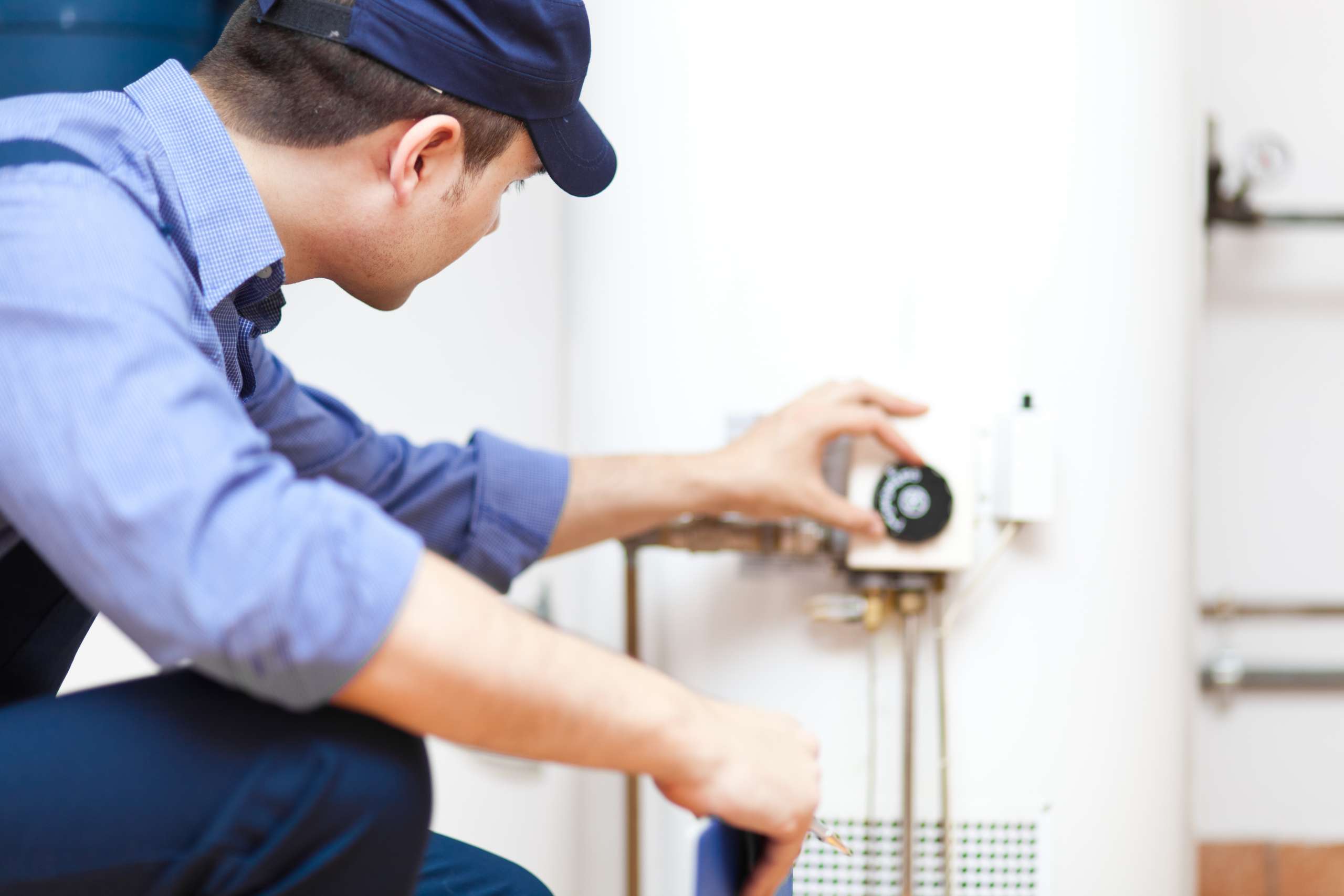 A technician repairing a hot-water heater