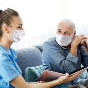 A caregiver doctor with a senior man at home