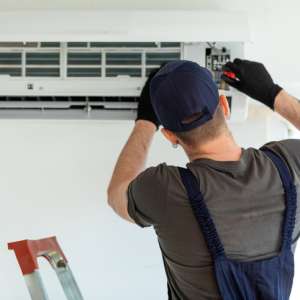 An electrical technician repairs air conditioner