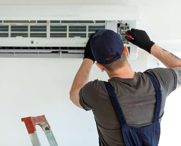 An electrical technician repairs air conditioner