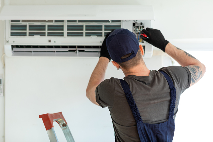 An electrical technician repairs air conditioner