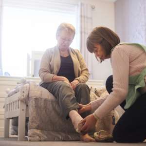 A home caregiver helps senior woman