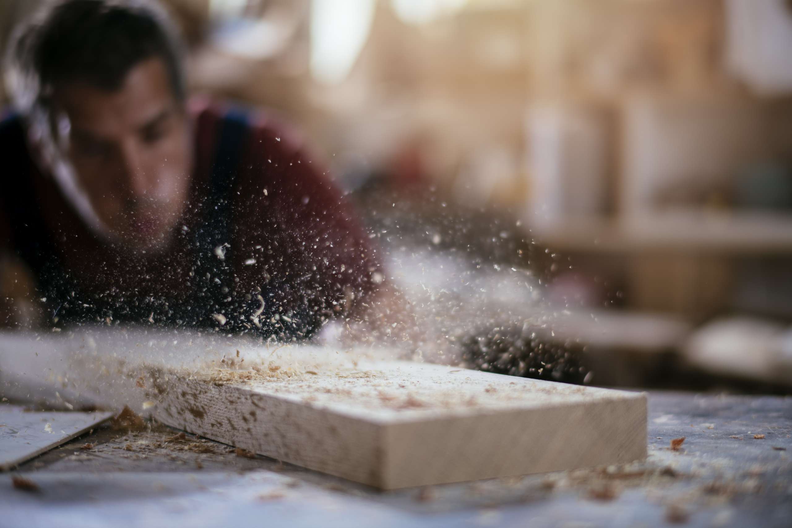 A carpenter working with wood at workshop