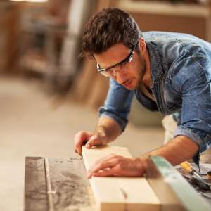 Carpenter cutting wooden plank