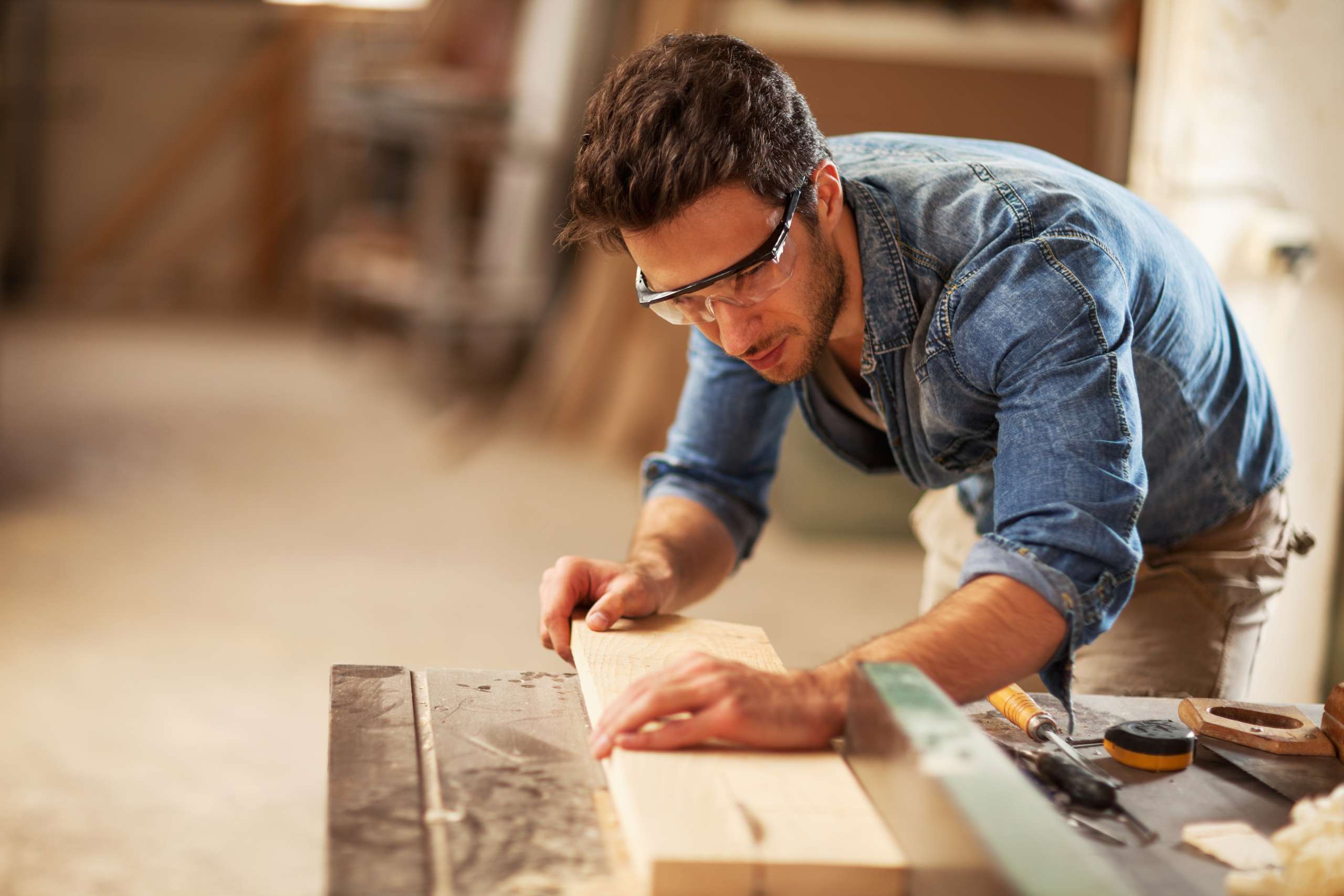 Carpenter cutting wooden plank