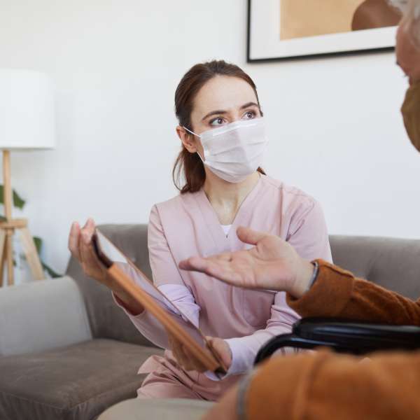Female Nurse Helping Senior Man at Home