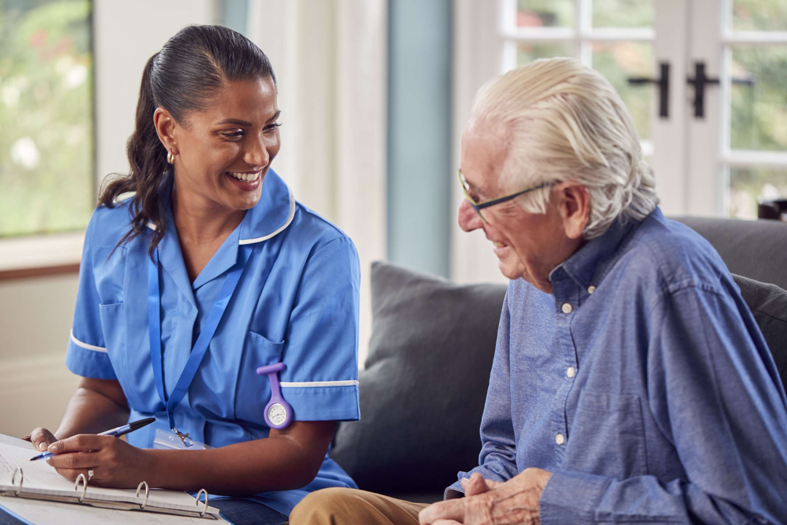 Senior Man At Home Talking To Nurse