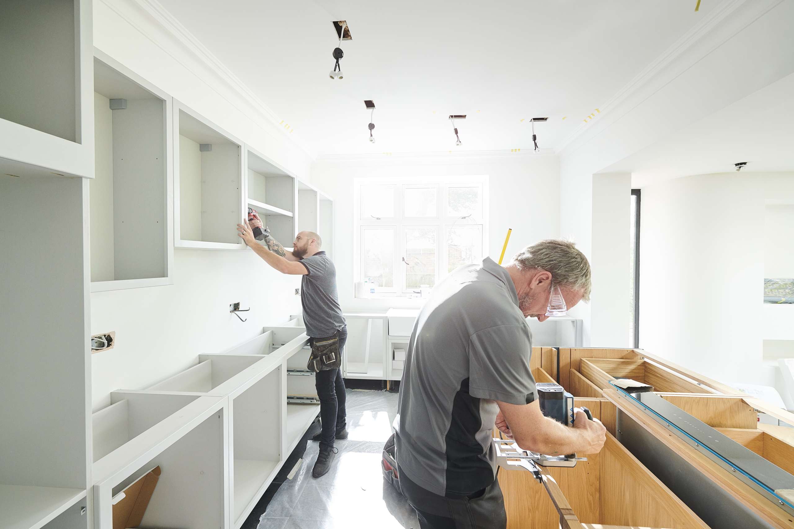Two carpenters fitting a kitchen