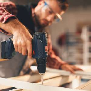 Tradesperson working with drill in the workshop