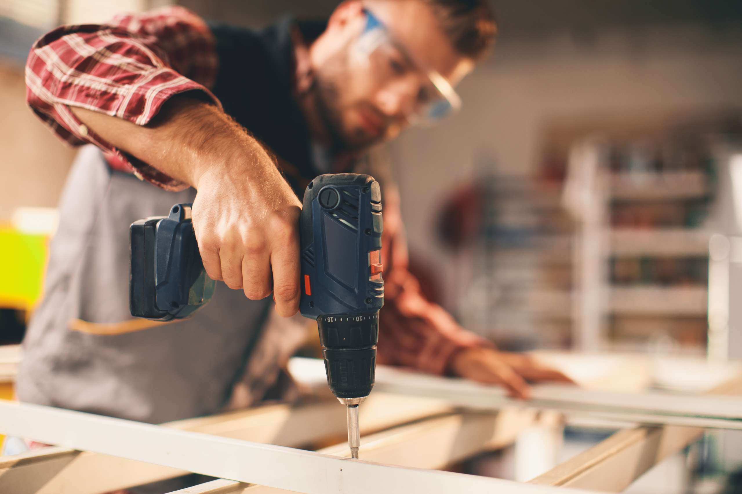 Tradesperson working with drill in the workshop