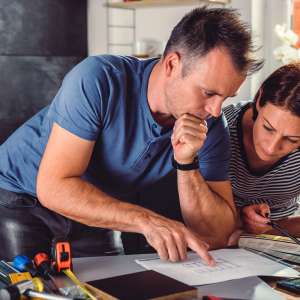 Two persons looking at home renovation blueprint