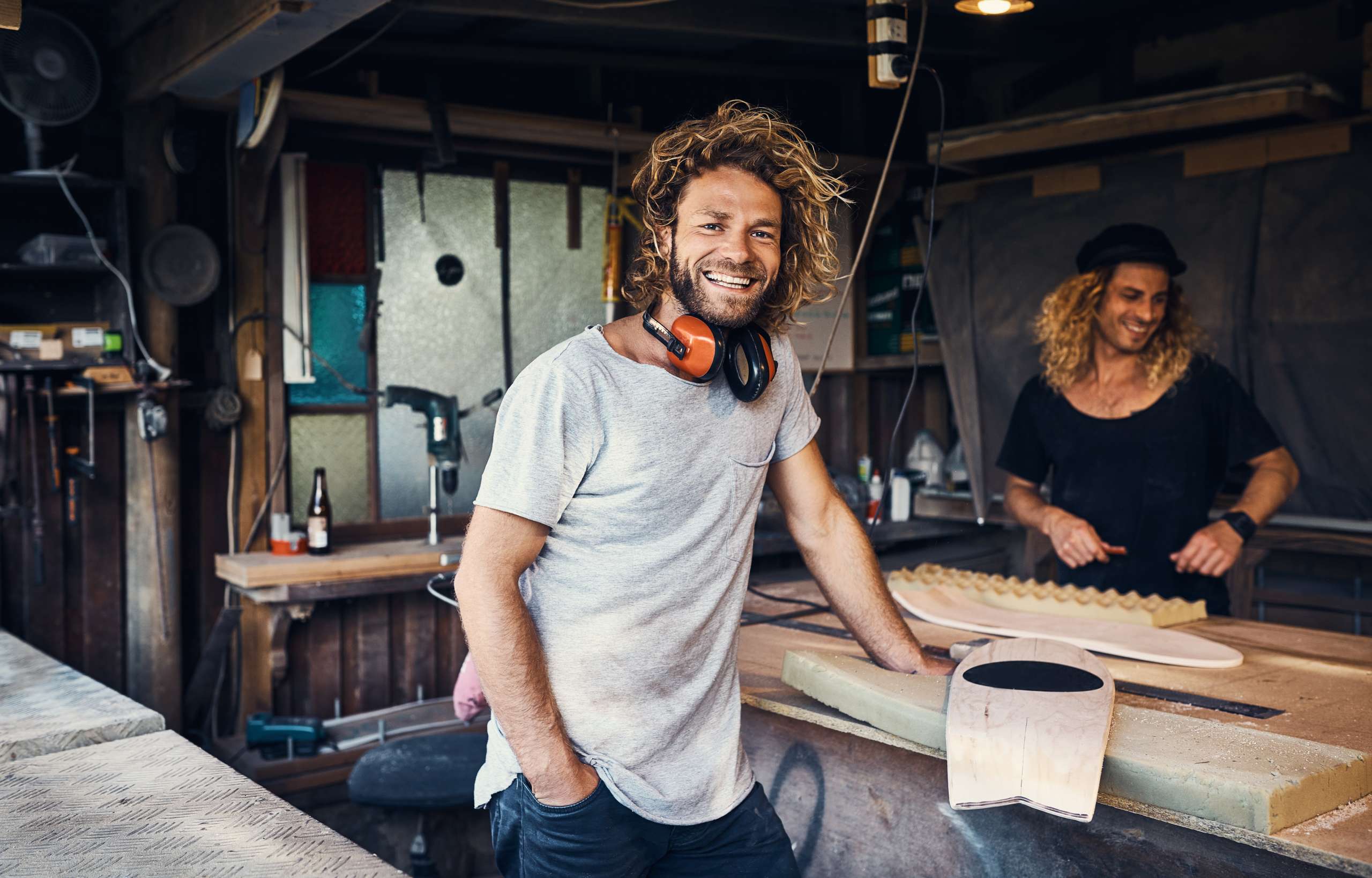 Two happy young men working on in their workshop