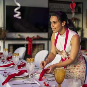 A woman is decorating the tables of a party