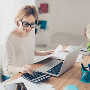 Happy consultant working with computer and calculator