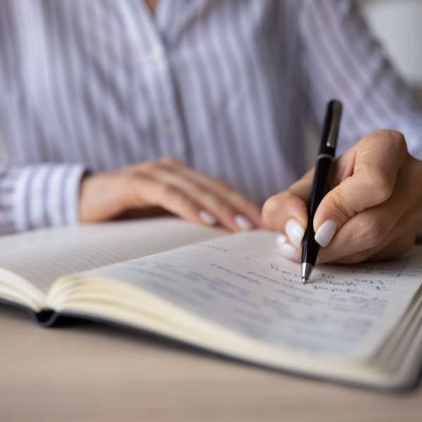 Woman makes notes in notebook