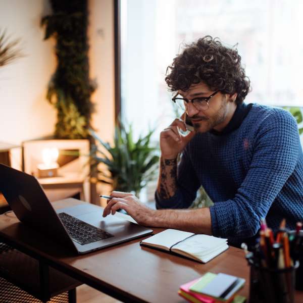 Young man talking on the phone in his home office