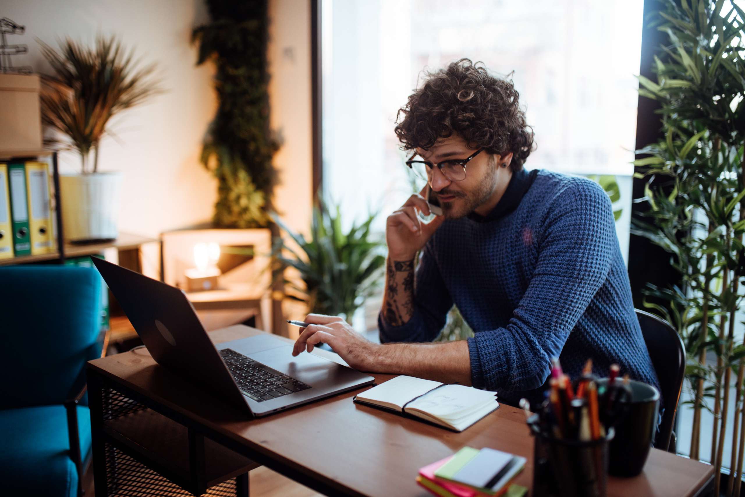 Young man talking on the phone in his home office