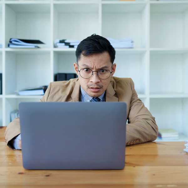 Portrait of a business owner using computer and financial statements.