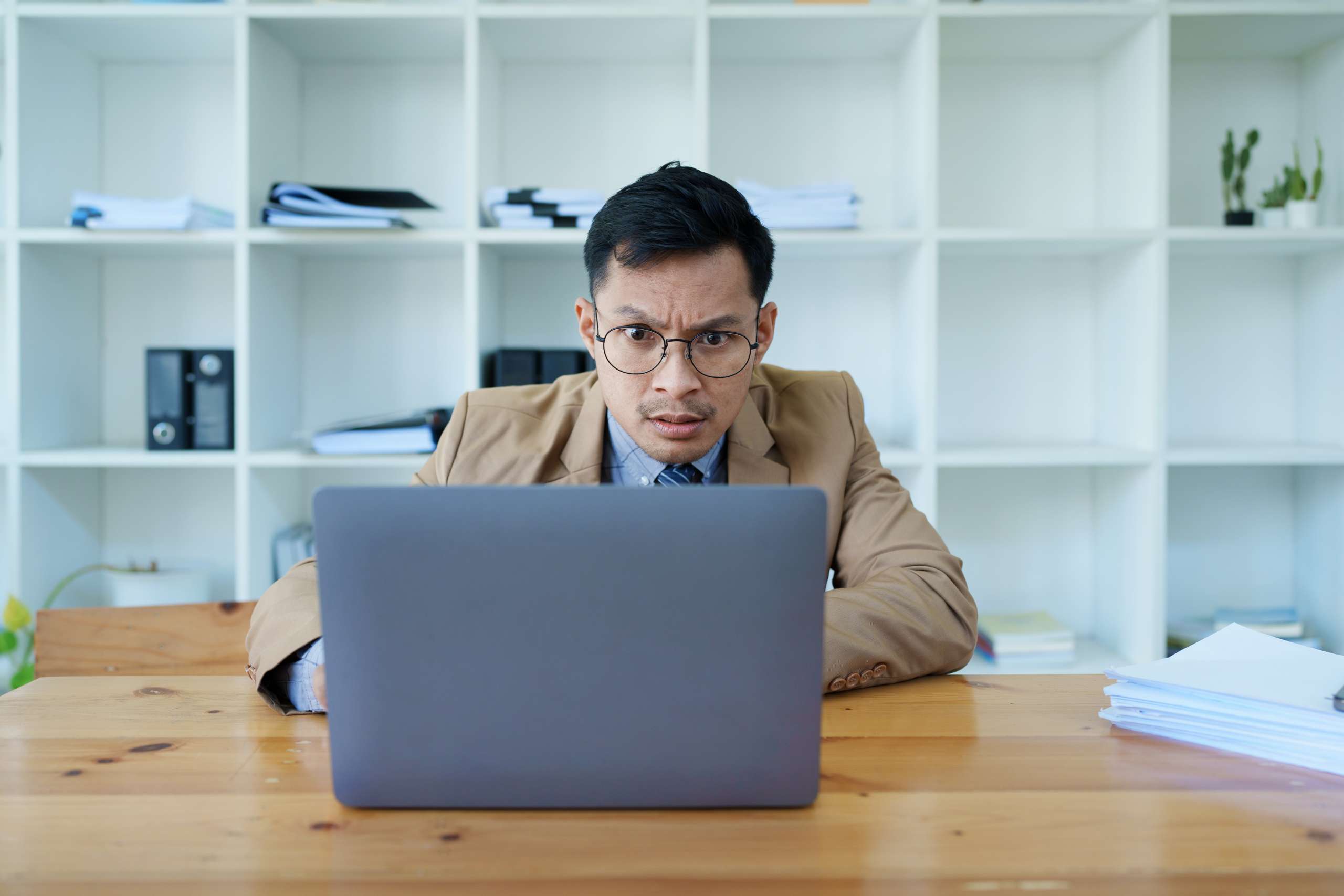 Portrait of a business owner using computer and financial statements.