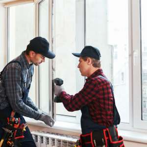 Starting a door and window installation business: Two technicians installing a window