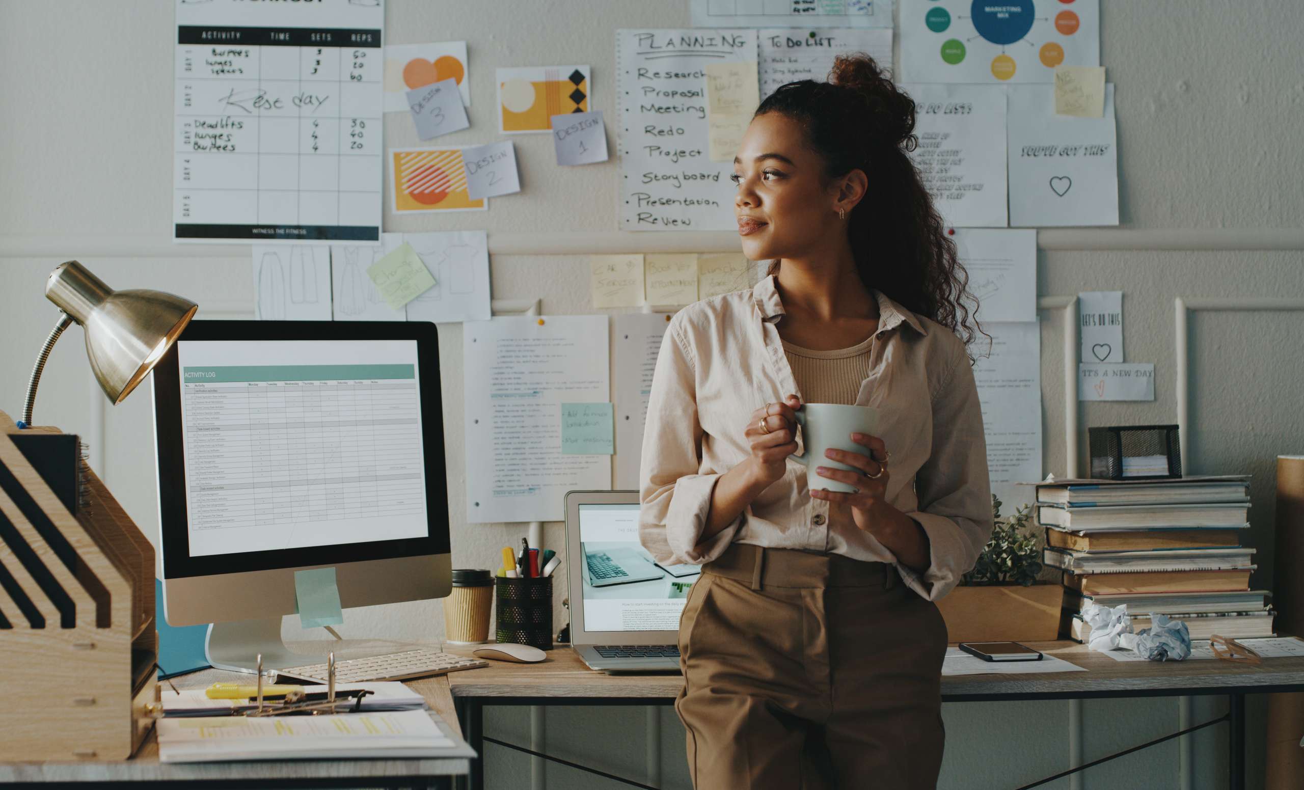 Shot of a young businesswoman standing and looking while holding a cup of coffee in her home office