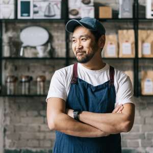 Confident cafe owner standing at his coffee shop