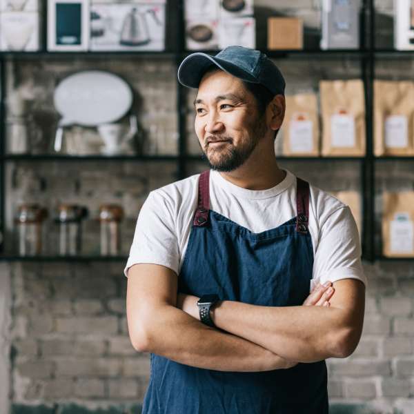 Confident cafe owner standing at his coffee shop