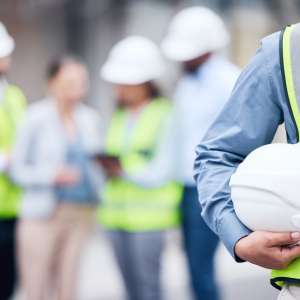 Architect holding a helmet at a building site