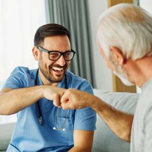 Caregiver with senior man at home.