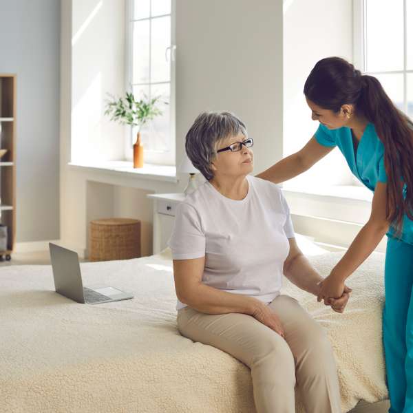 Female home care nurse supports and assists senior woman