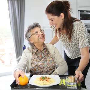 Homecarer preparing lunch for elderly woman