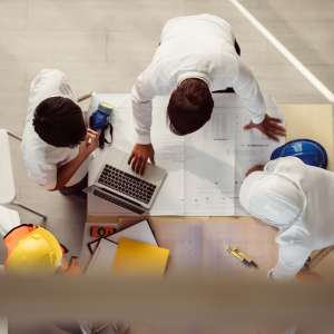 Top view of consultants wear safety helmet in new project meeting.