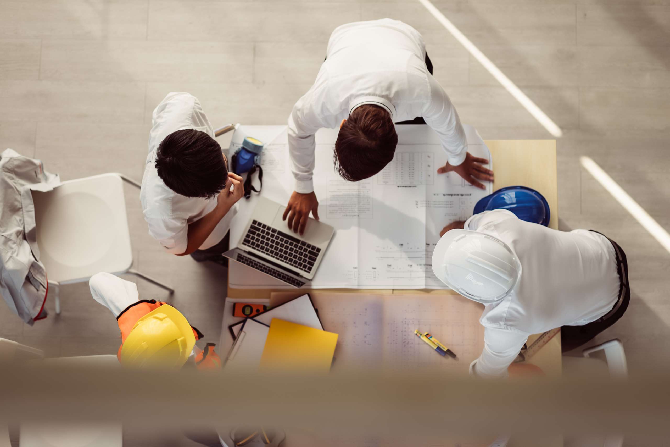 Top view of consultants wear safety helmet in new project meeting.