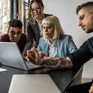 A group of marketing executives engages in a meeting at their office, brainstorming and discussing innovative ideas with enthusiasm.
