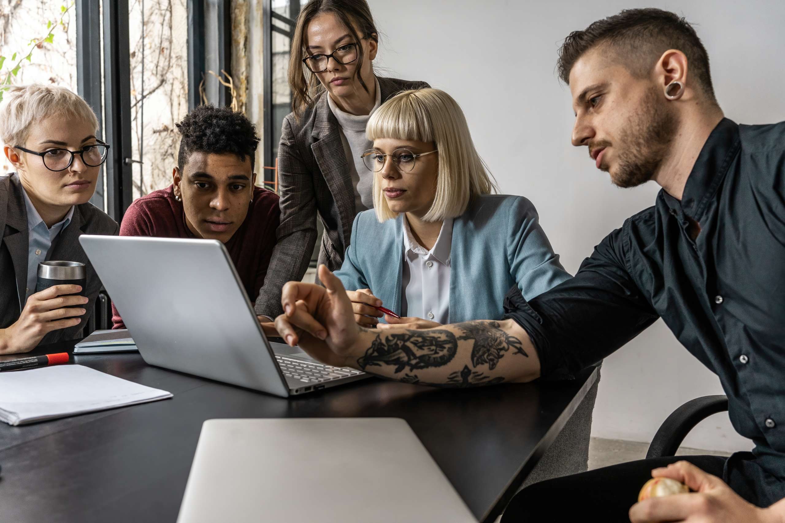 A group of marketing executives engages in a meeting at their office, brainstorming and discussing innovative ideas with enthusiasm.