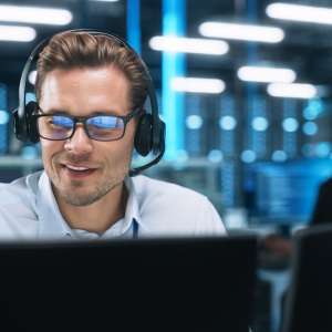 Businessman with headset, in office, talking on video conference with client
