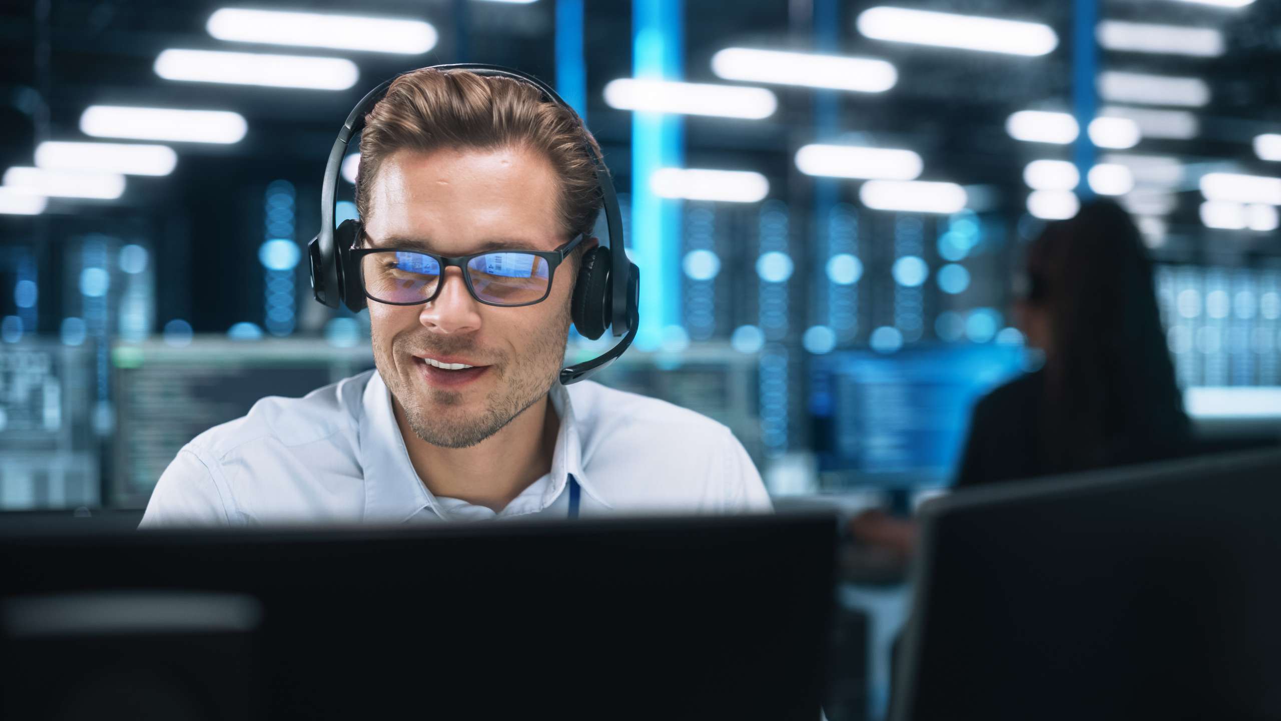 Businessman with headset, in office, talking on video conference with client