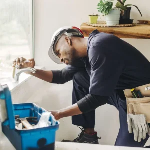 A handyman fixing a leaking bathroom faucet