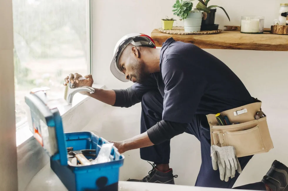 A handyman fixing a leaking bathroom faucet