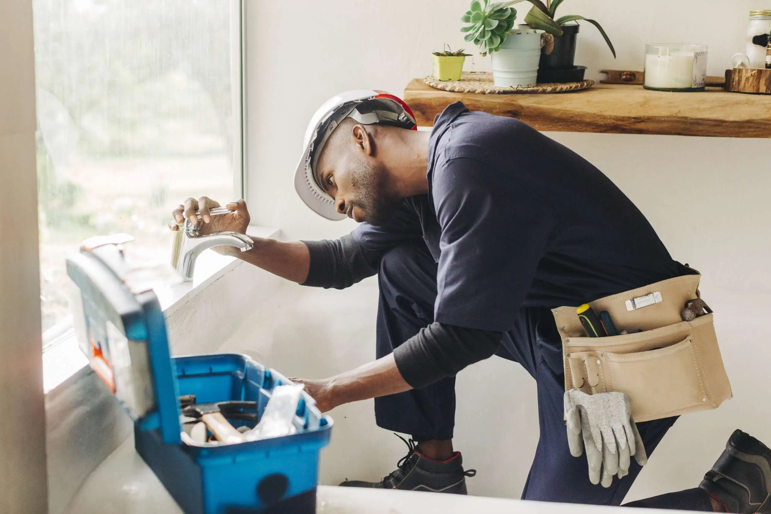 A handyman fixing a leaking bathroom faucet