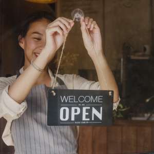 Business owner changing a sign to open