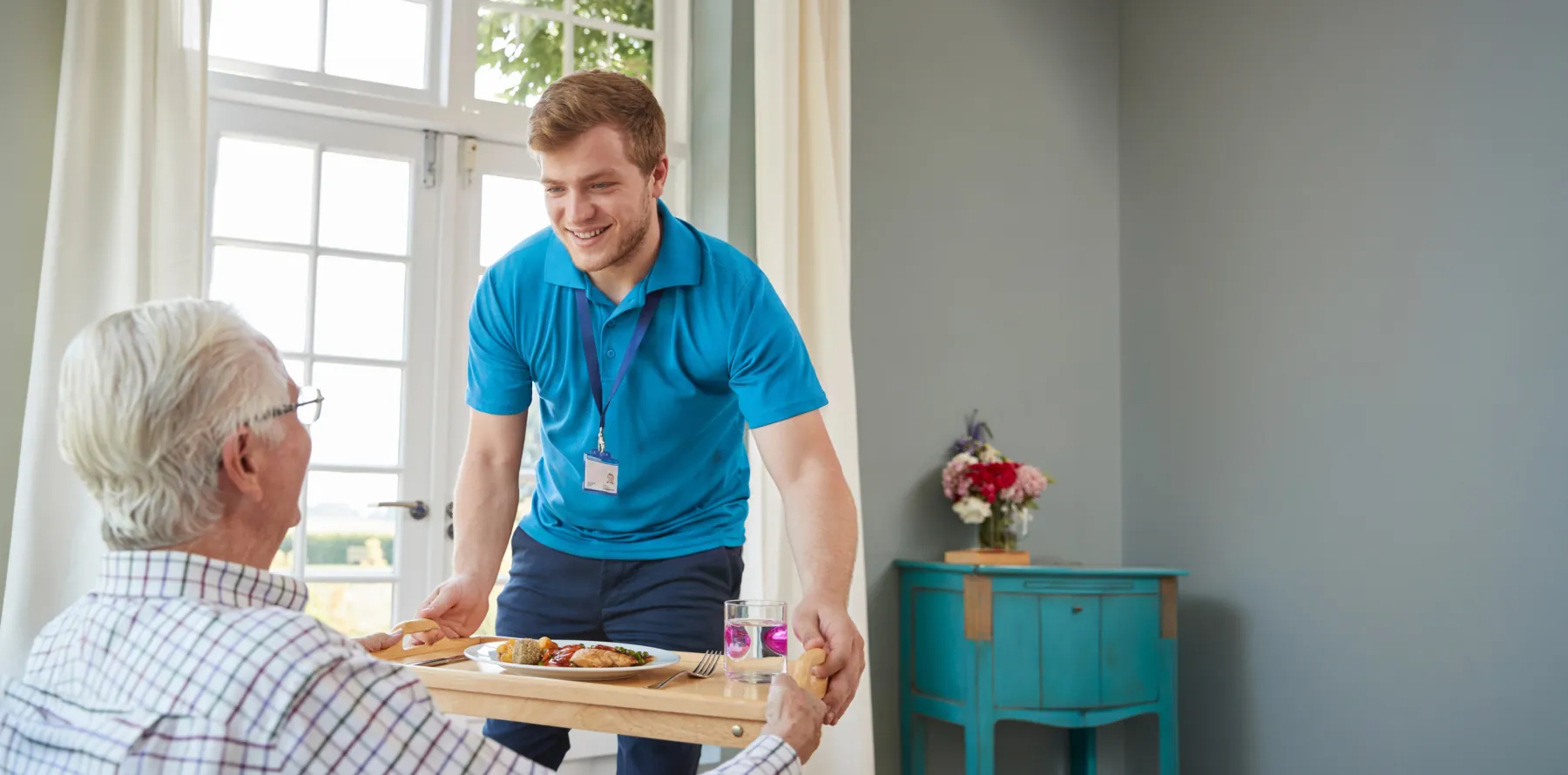 Adult day care professional serving food to a patient. 