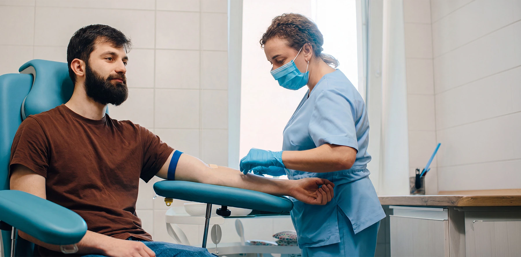 Phlebotomist at workplace with a patient about to draw blood for lab tests