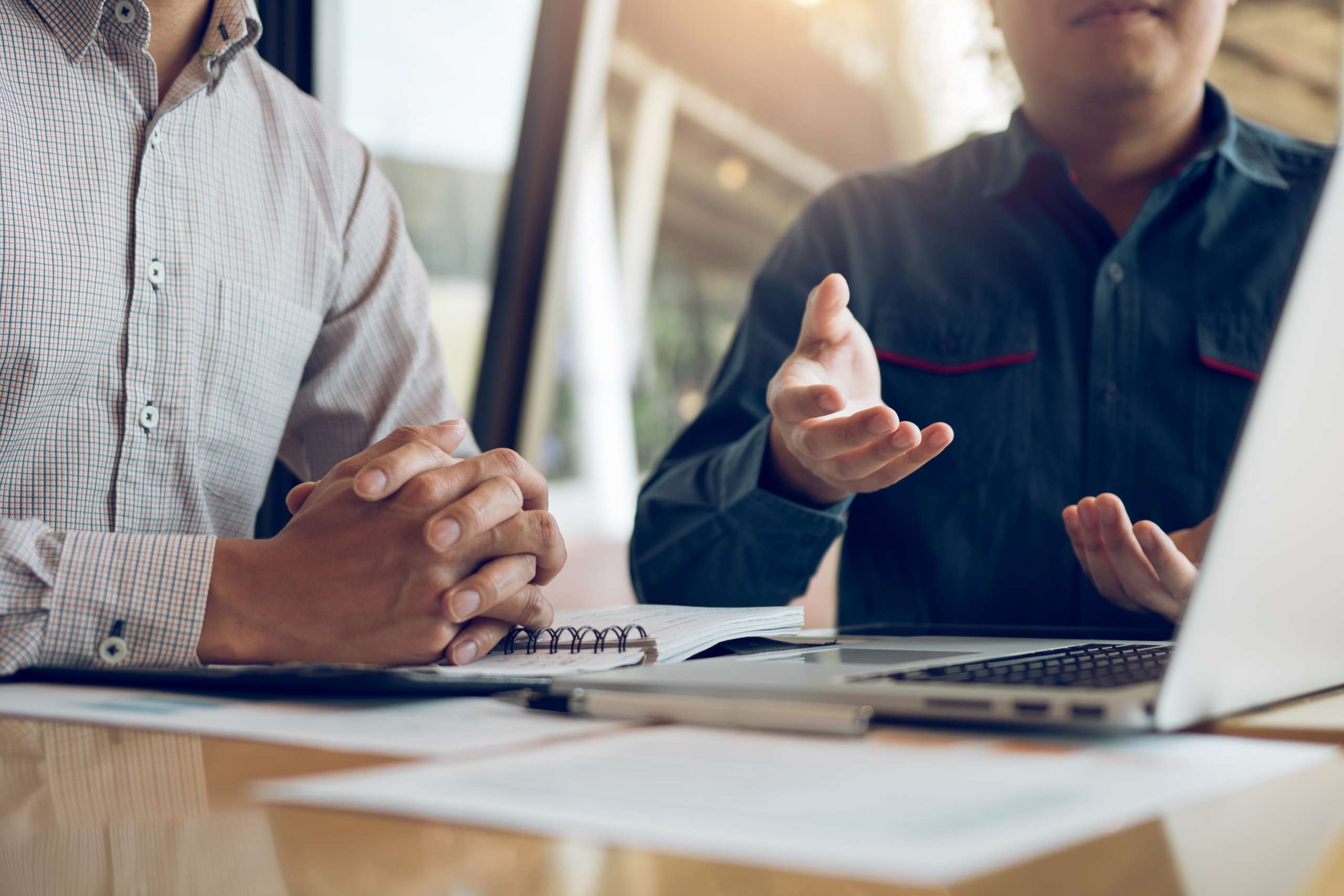 Two businessmen are discussing about the financial budget of the company and sharing the correct analysis.
