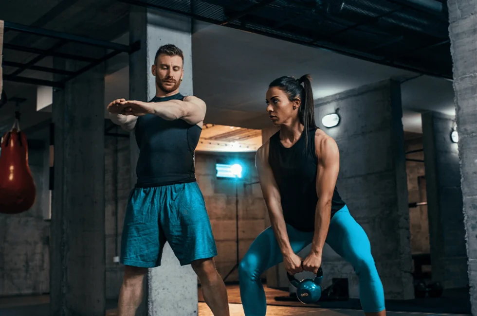 Personal trainer having a PT session with a client while doing an exercise.