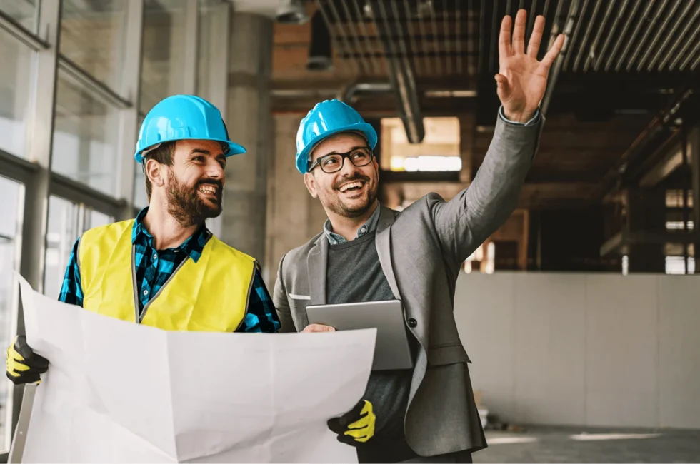 General contractors at a worksite with blueprints on their hands