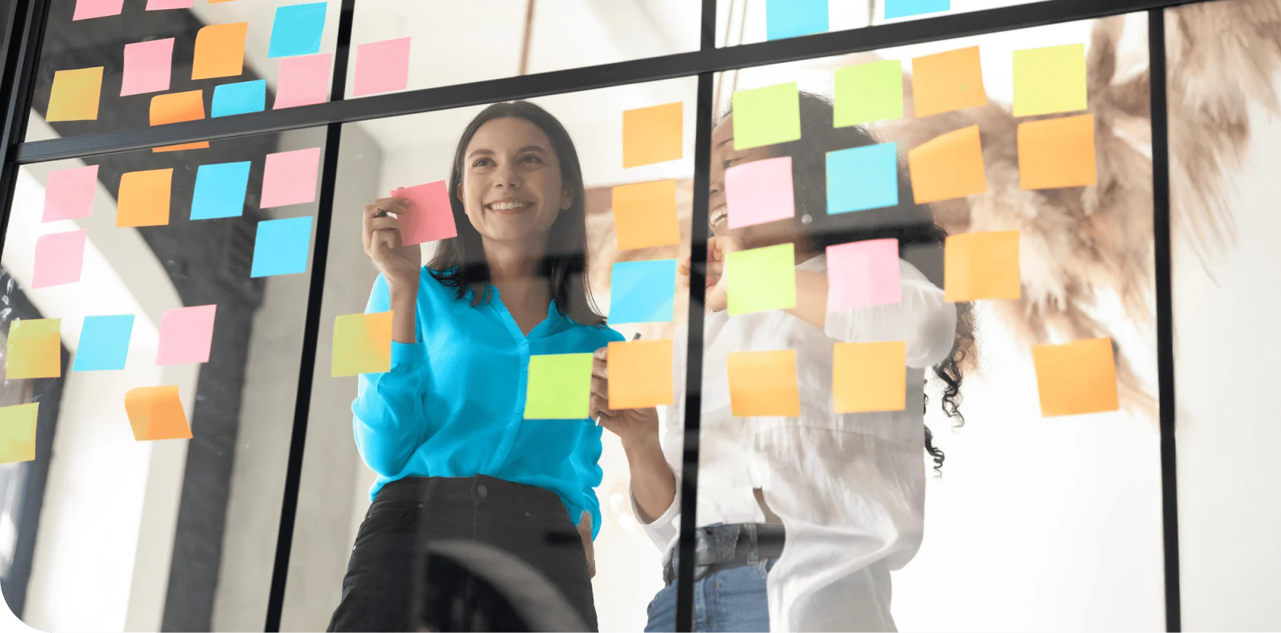 Marketing Consultant in a brainstorming session with a colleague using colourful post-its