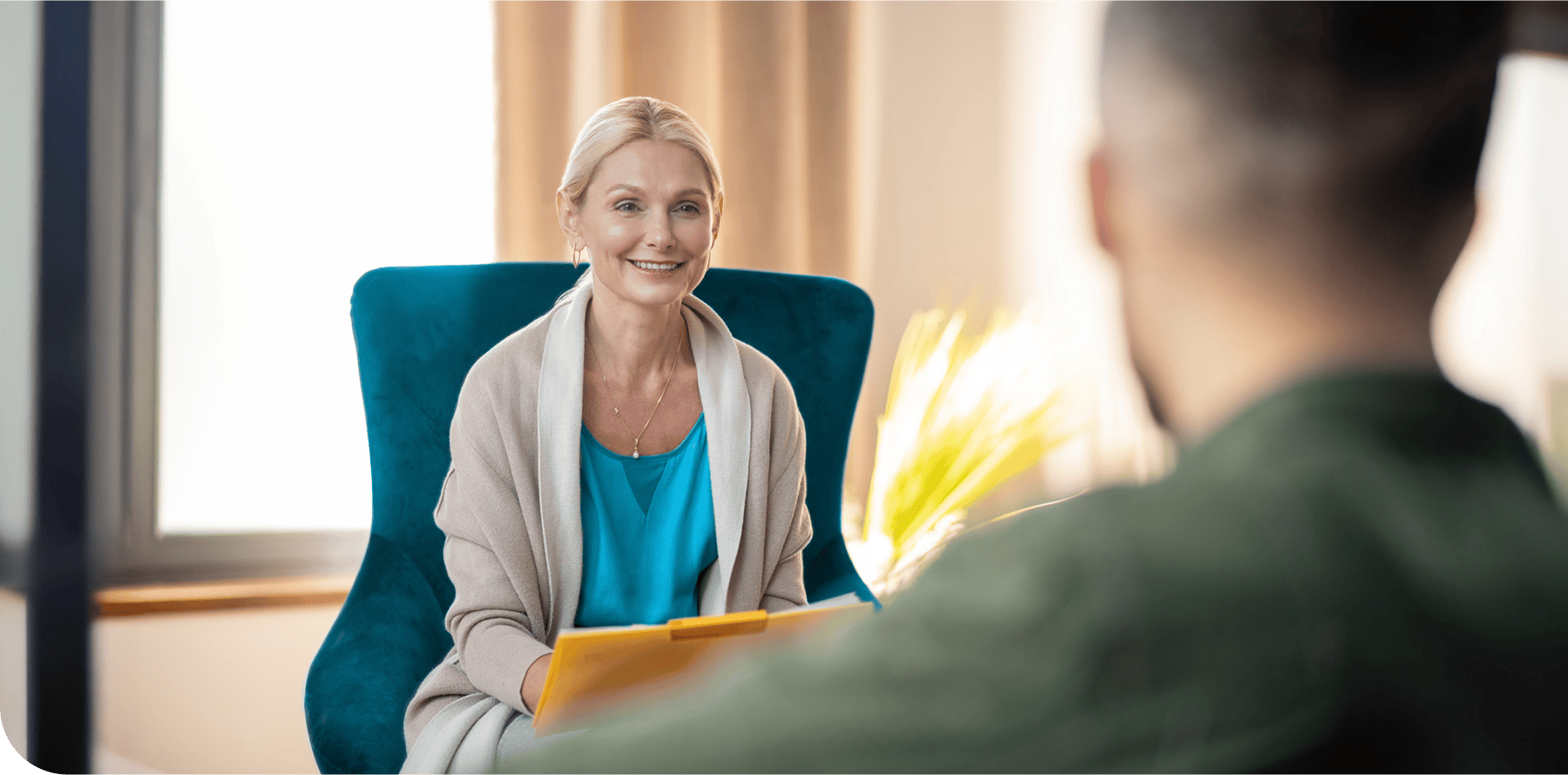 Woman phsychologist who is taking notes using a notepad while having a conversation with a client